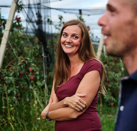 Apple farmer woman smiling at apple farmer in the orchard