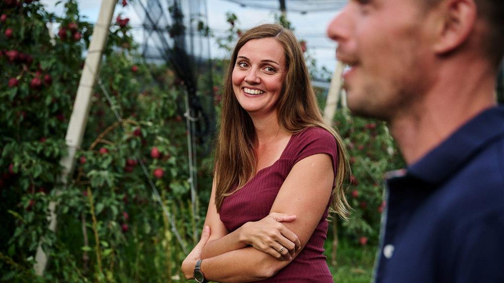 Apple farmer woman smiling at apple farmer in the orchard